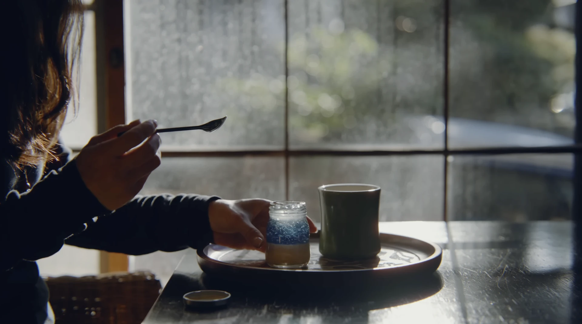 光の差す窓辺で、瓶入りのおやつと温かい飲みものを楽しむ