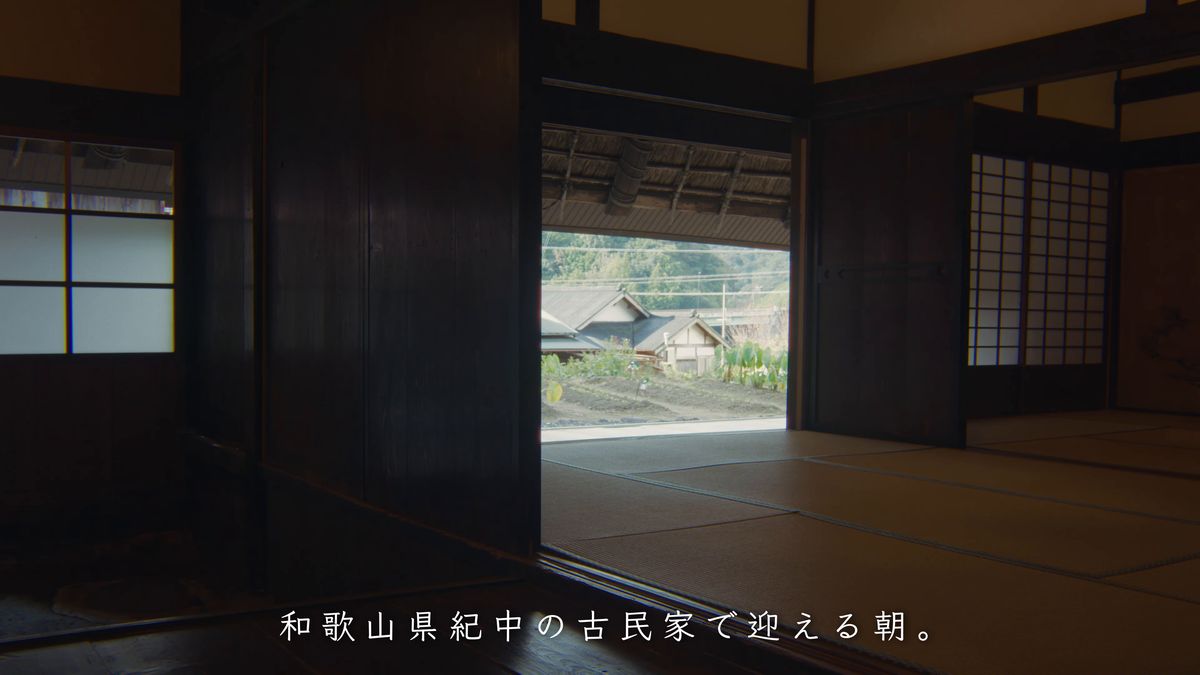 開け放した戸の向こうに集落が見える畳の間