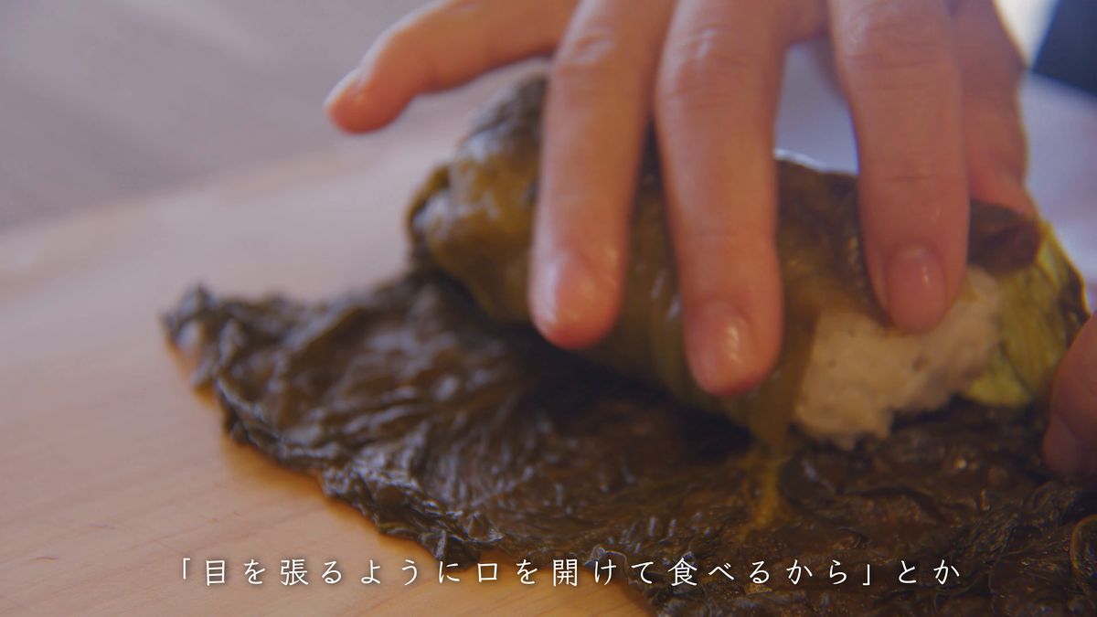 葉の端を折り込んで包む手元