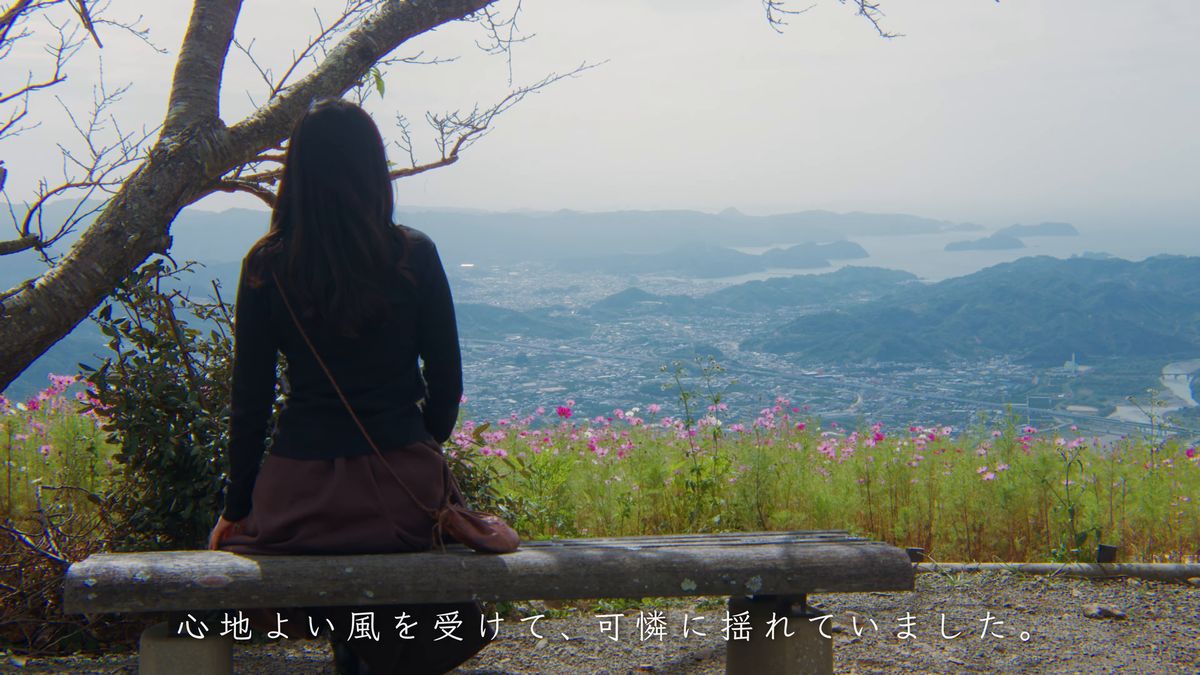 ベンチに座って景色を眺める後ろ姿