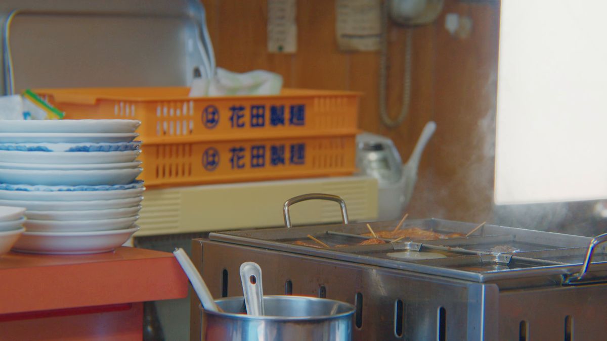 製麺所の箱と重ねた丼が並ぶ厨房の脇