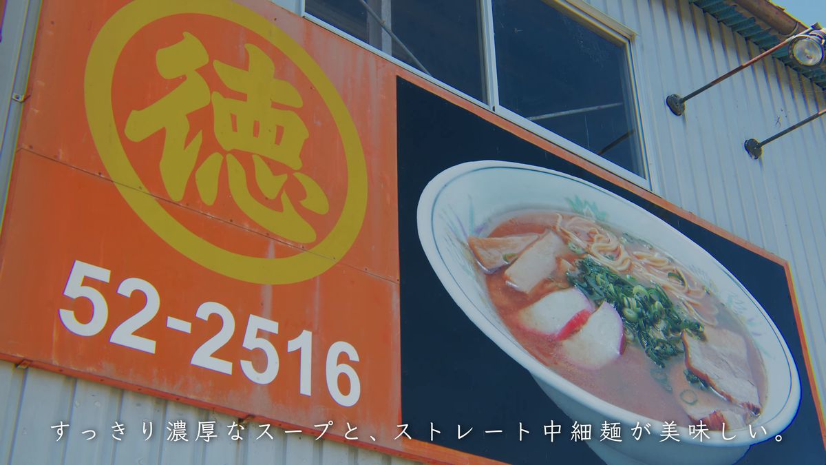 ラーメンの写真と「徳」の字が描かれた看板