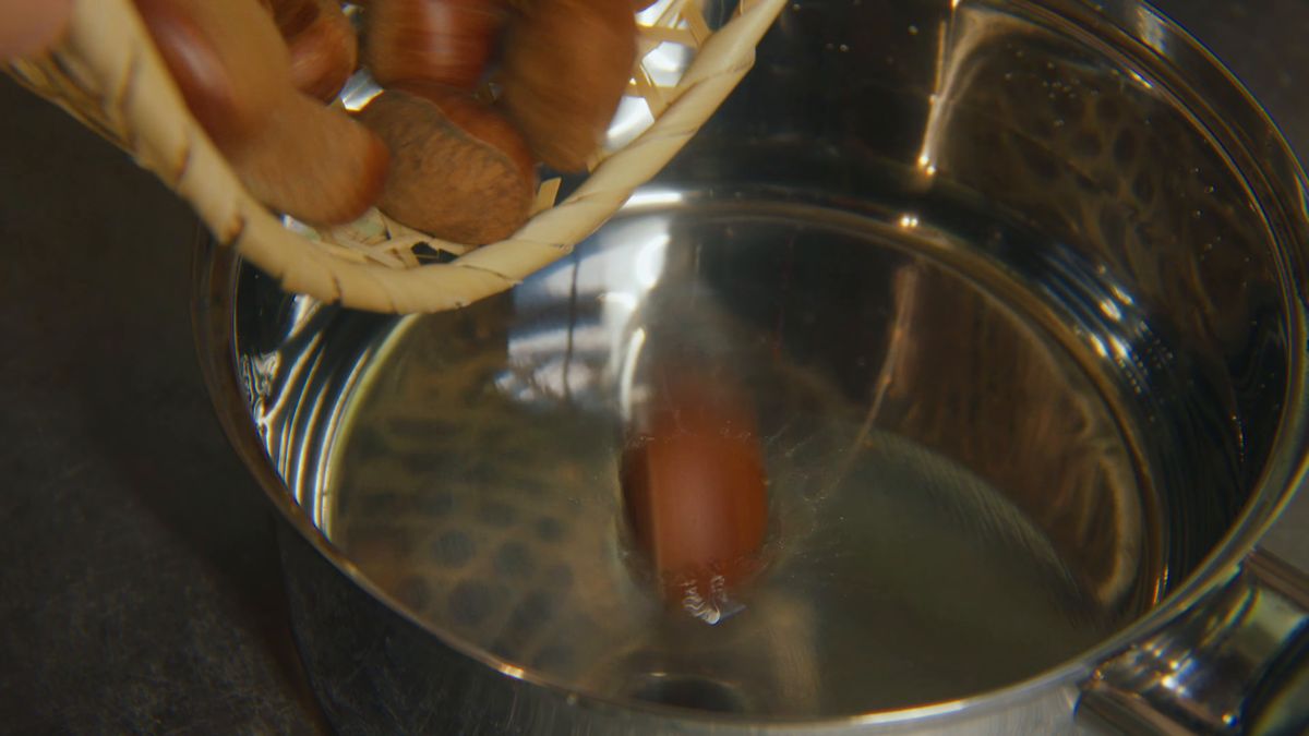 かごから鍋へ栗を移す