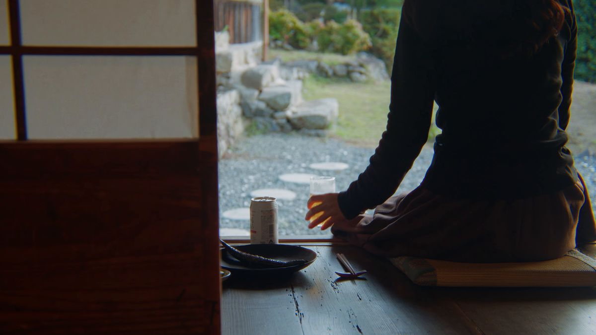 縁側に腰かけて庭を眺める後ろ姿