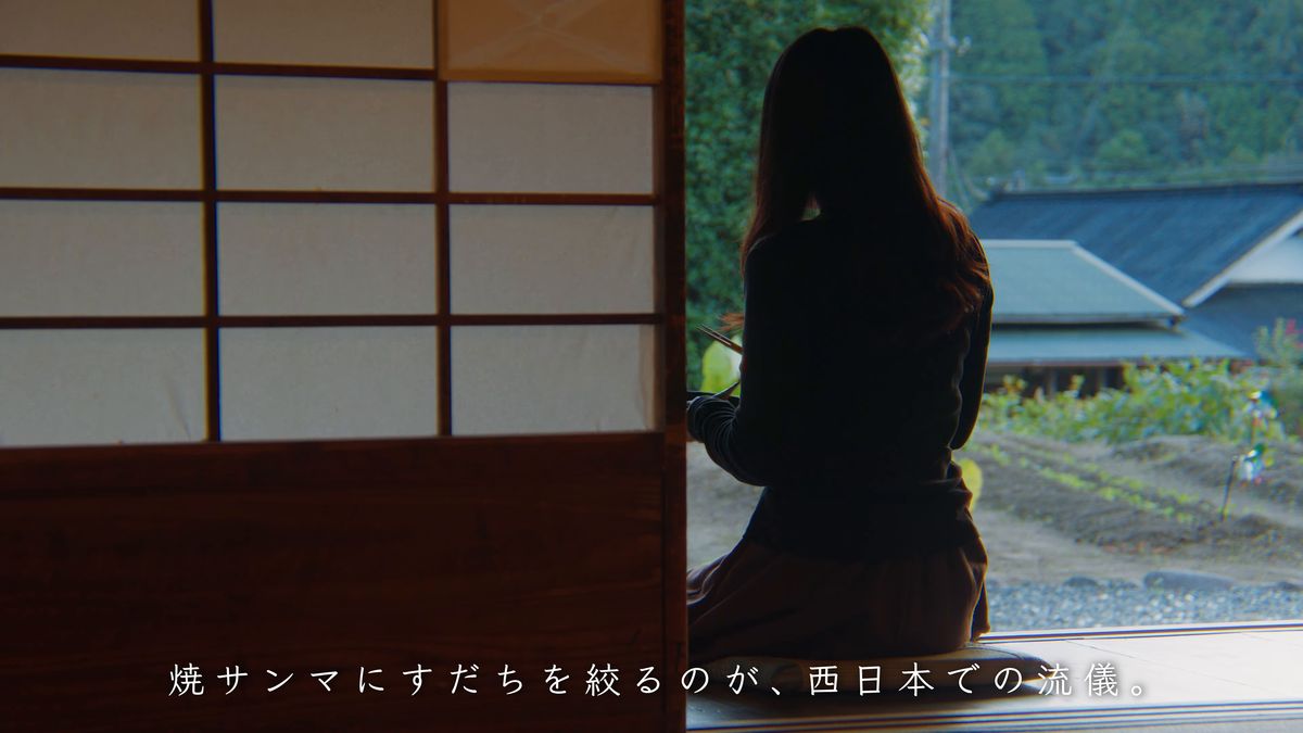 障子の戸口に座る後ろ姿と外の畑
