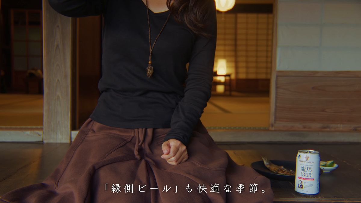 缶とグラスを脇に縁側に座る
