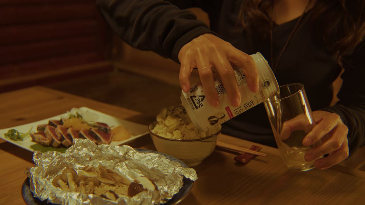 料理の並ぶ食卓でグラスに注ぐ