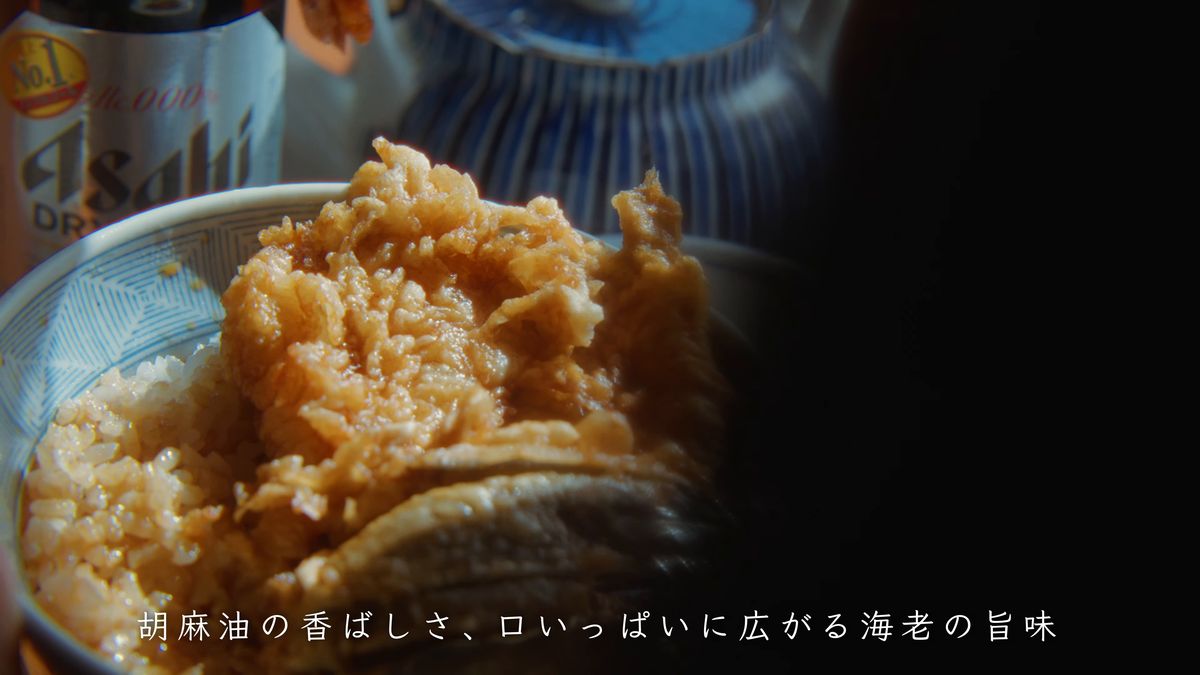 胡麻油で揚げた濃い色の天ぷらがのる天丼