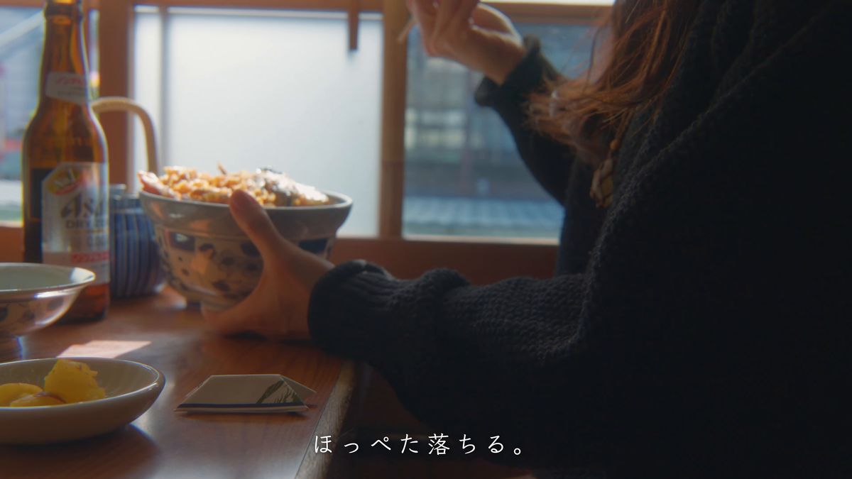 窓辺の席で天丼を手にする