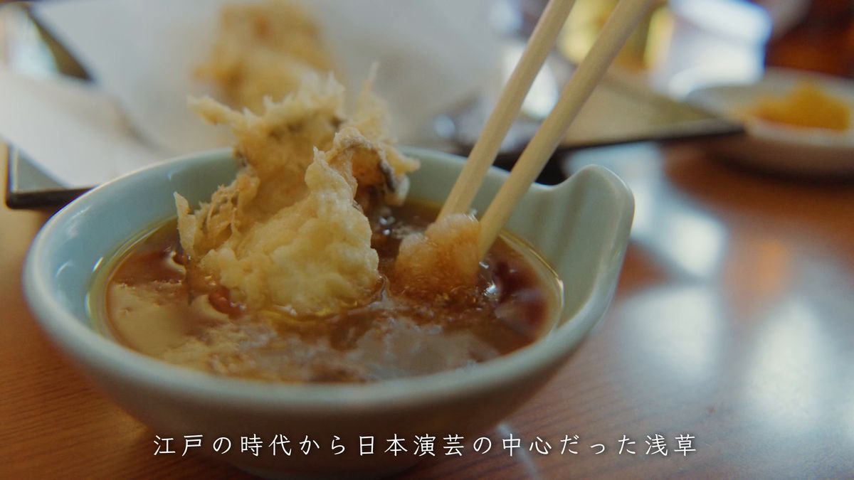 天つゆにくぐらせた牡蠣を箸で持ち上げる