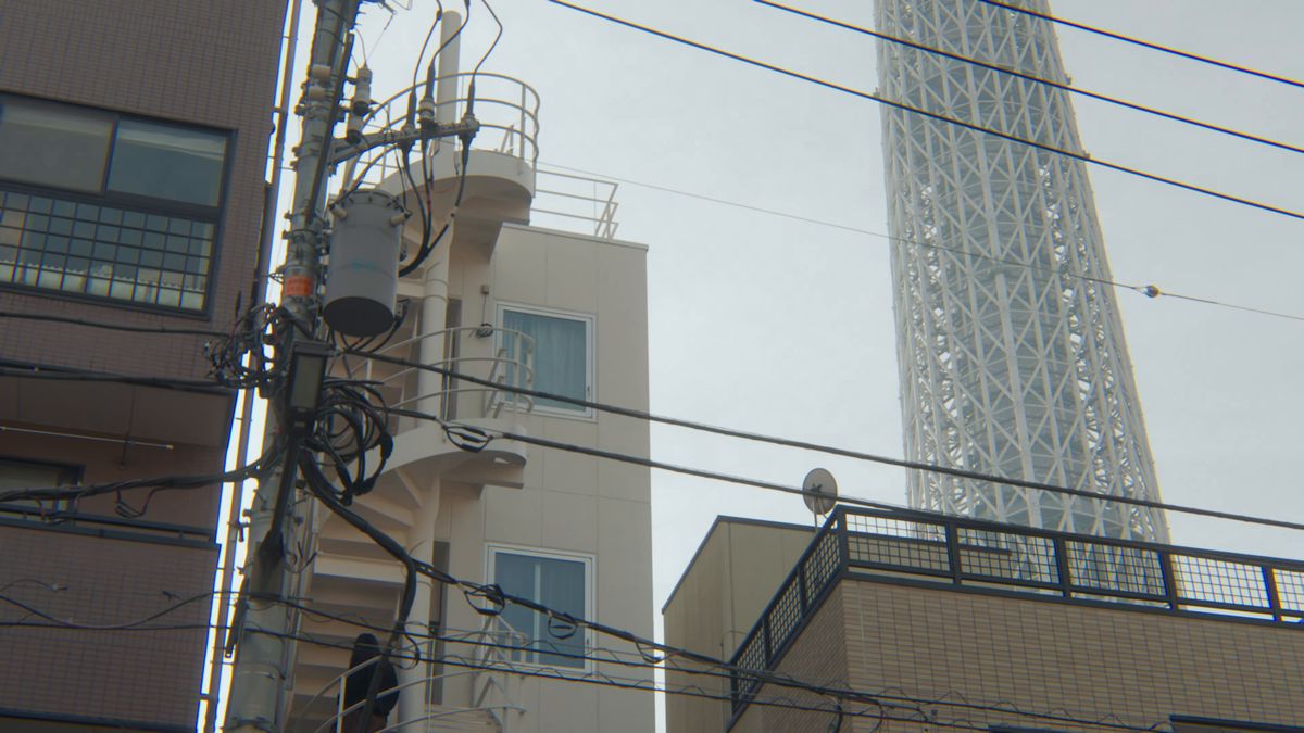 電線と建物の向こうにそびえるスカイツリー