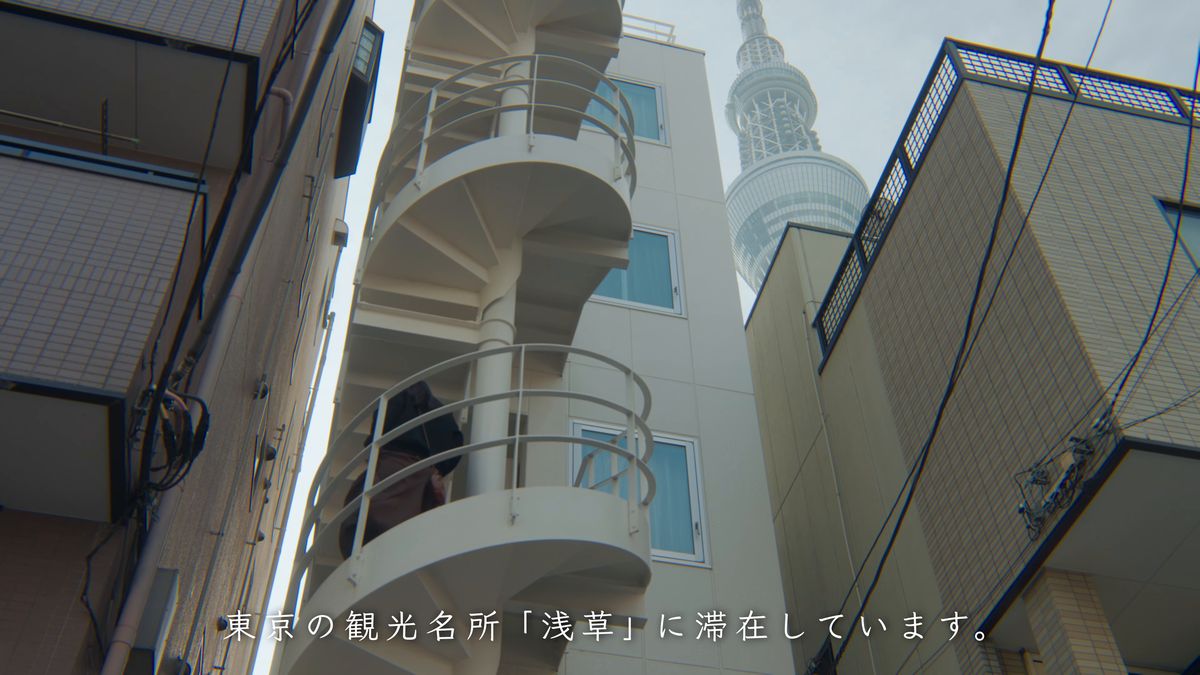 らせん階段のある建物の間からのぞくスカイツリー