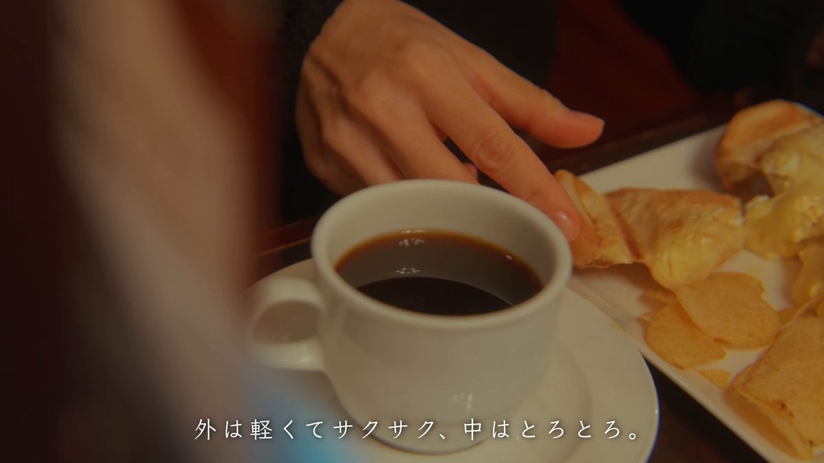 コーヒーの横のホットサンドの皿に手を伸ばす