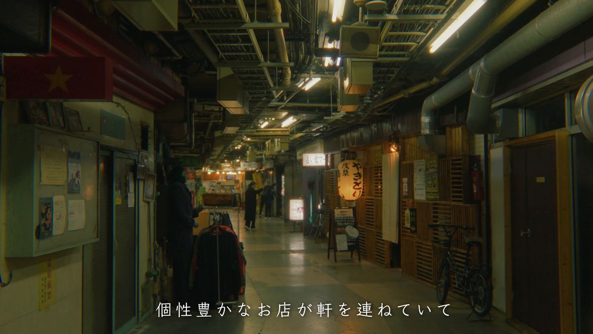 配管がむき出しの天井と、続く店々