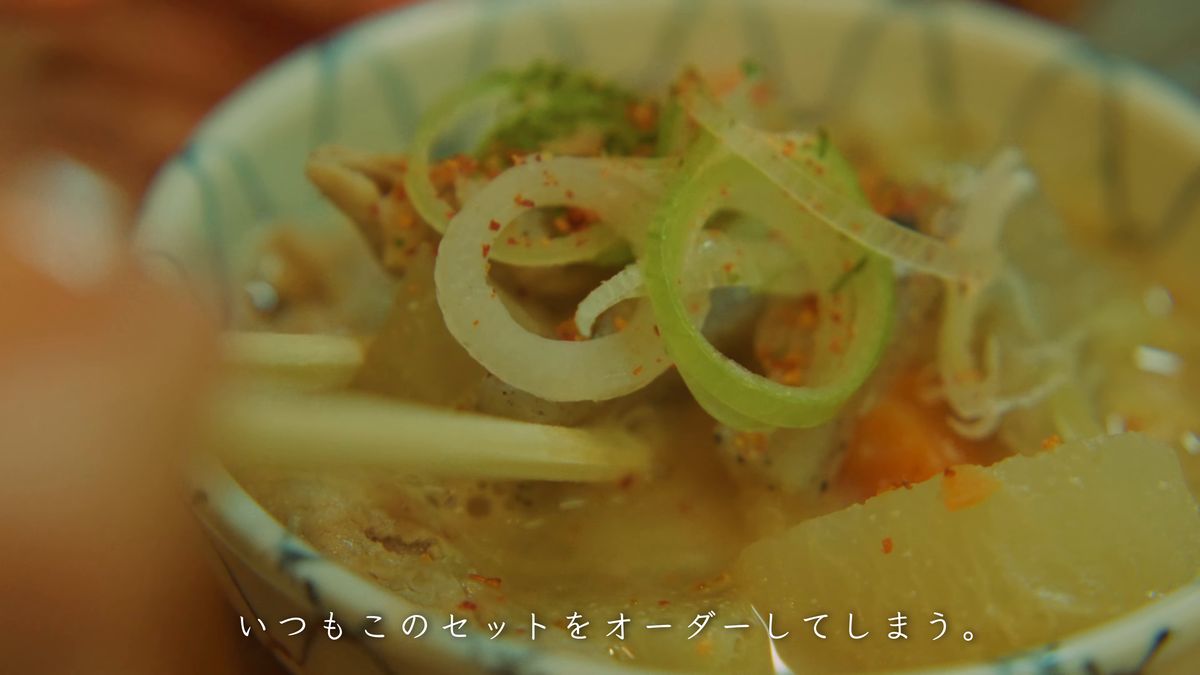 もつ煮込みを箸ですくう