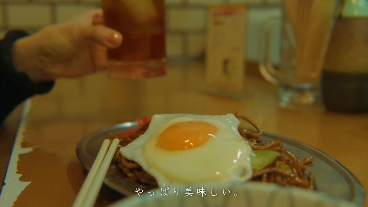 グラスを手に、目玉焼きのせ焼きそばを前に