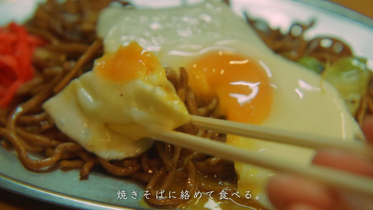 目玉焼きと麺を箸でまとめる