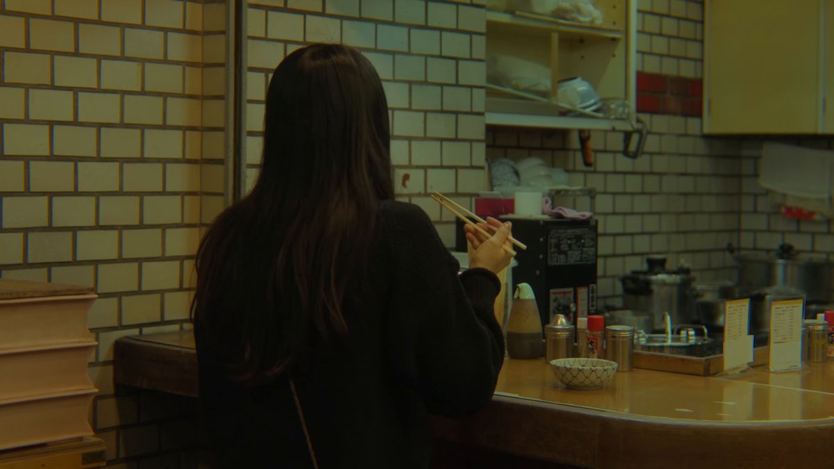 カウンターで焼きそばを食べる後ろ姿