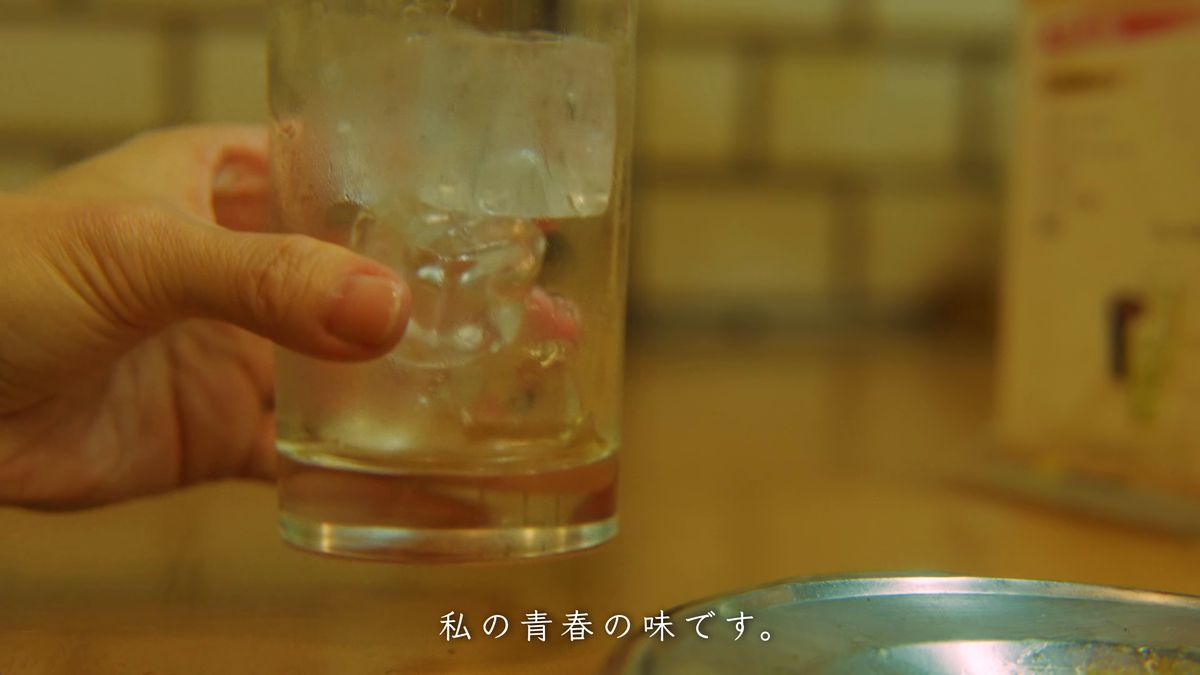氷の入ったグラスを手に