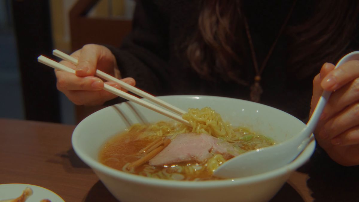 中華そばを箸で持ち上げる