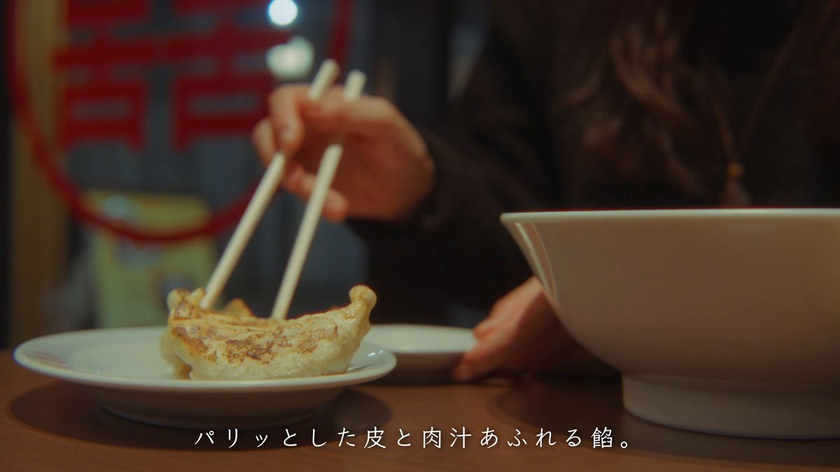 餃子を箸でつまむ