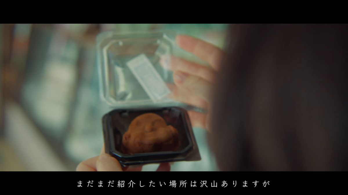 容器に入った人形焼をひとつ手に