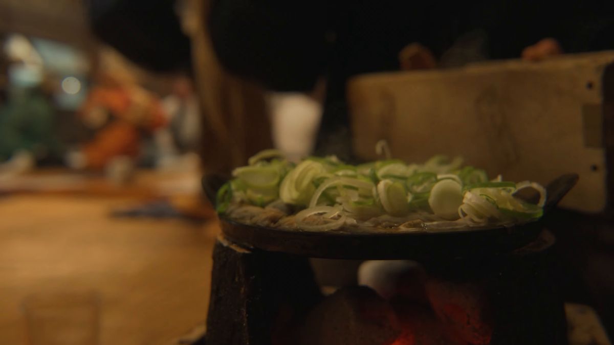 火鉢にのったネギ山盛りの鍋
