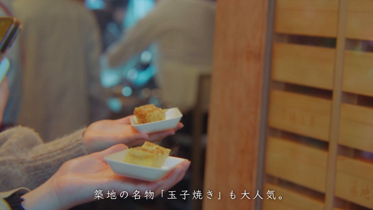 小皿の玉子焼きを手にした人