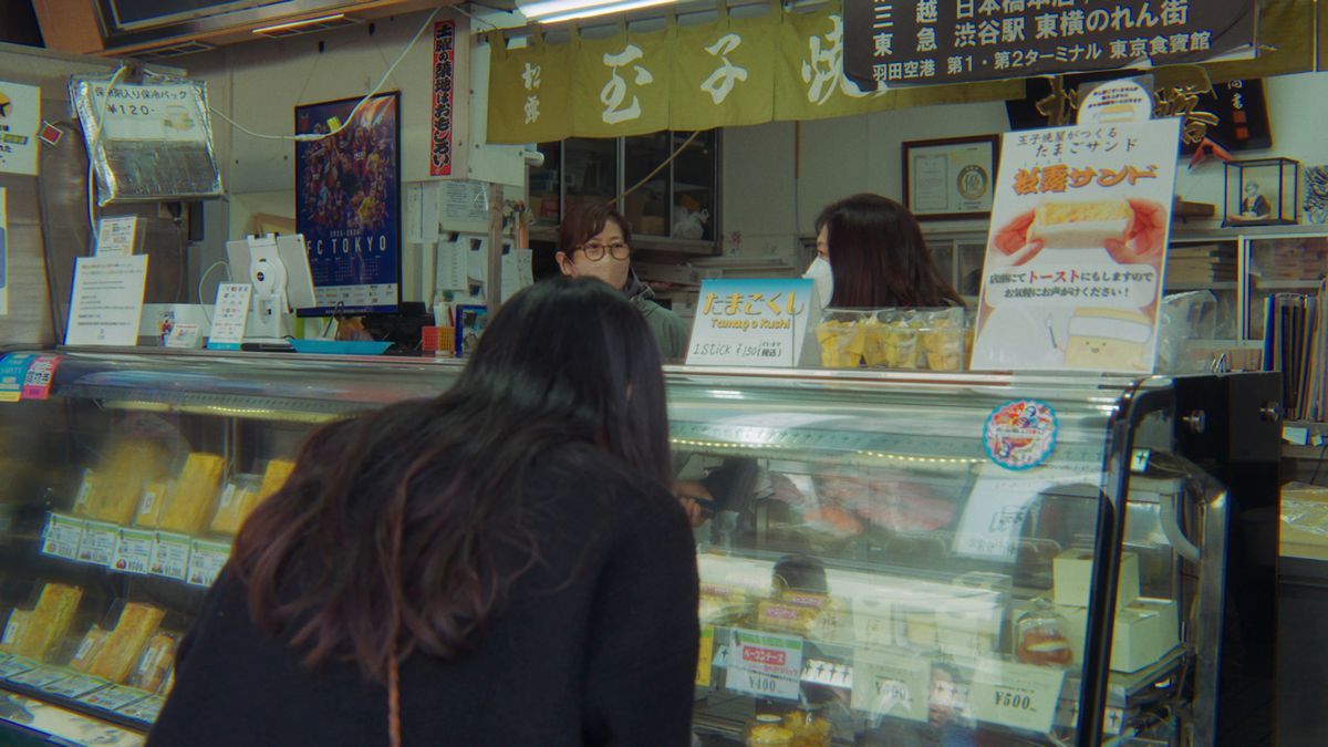 玉子焼の店先をのぞく後ろ姿