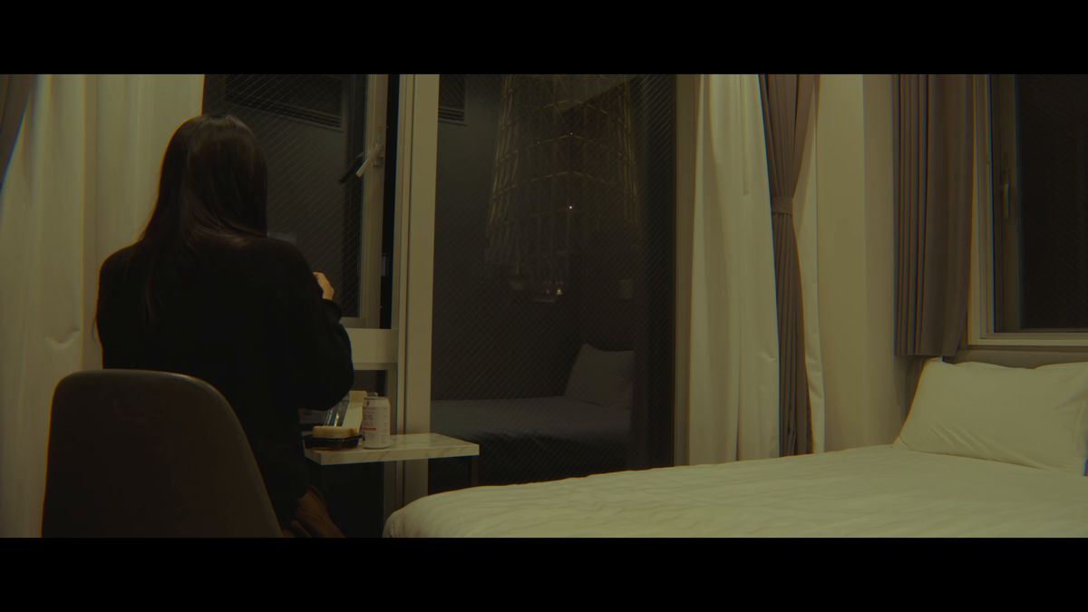 夜の窓辺に座る後ろ姿