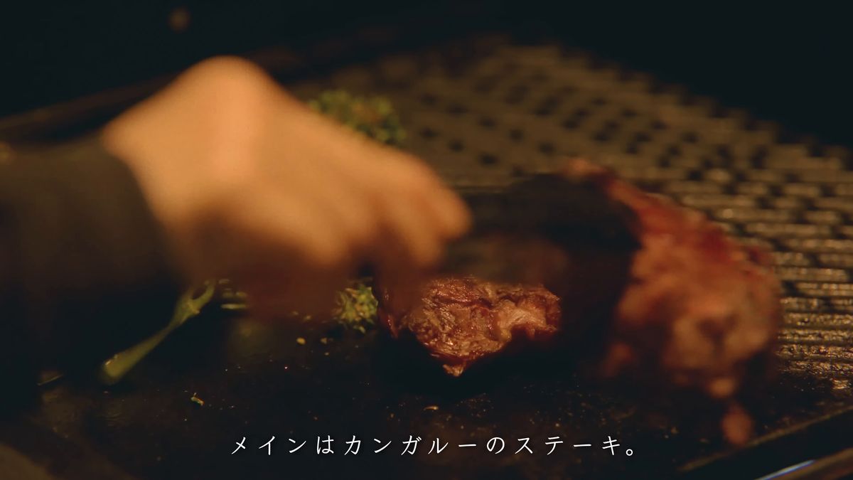 トングでステーキを返す