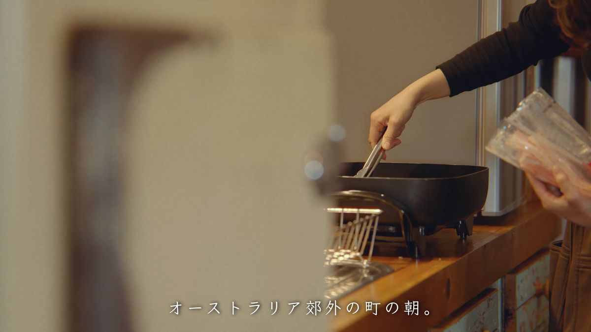 鉄のフライパンにトングを入れる手元