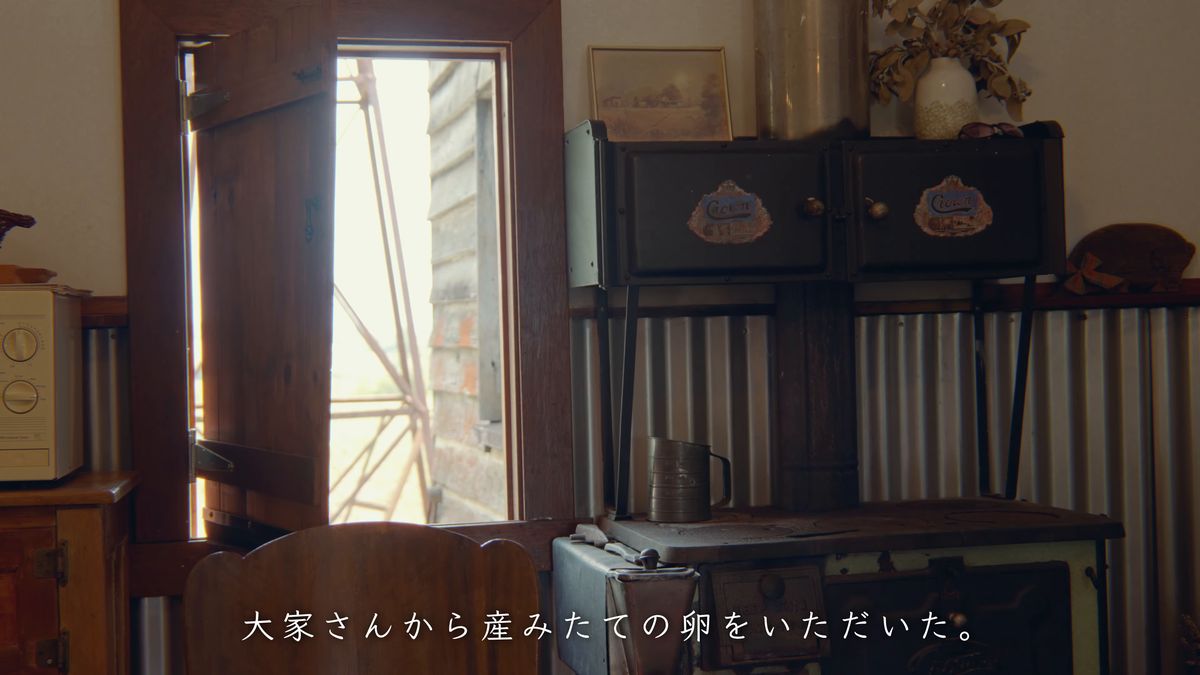 黒い薪ストーブと、戸の外の光