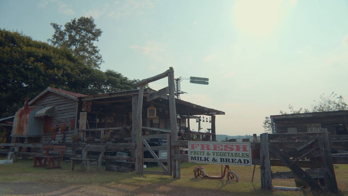 朝日の中の小屋と青果の看板