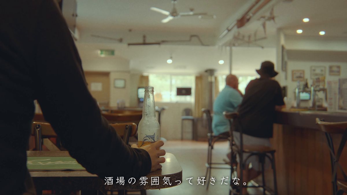 ビール瓶を手に店内を眺める