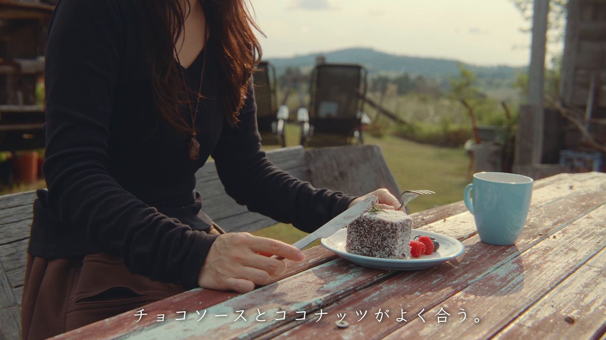 テラスのテーブルでラミントンを食べる