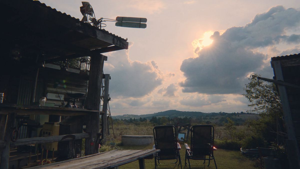 小屋の屋根と風車の向こうの夕空
