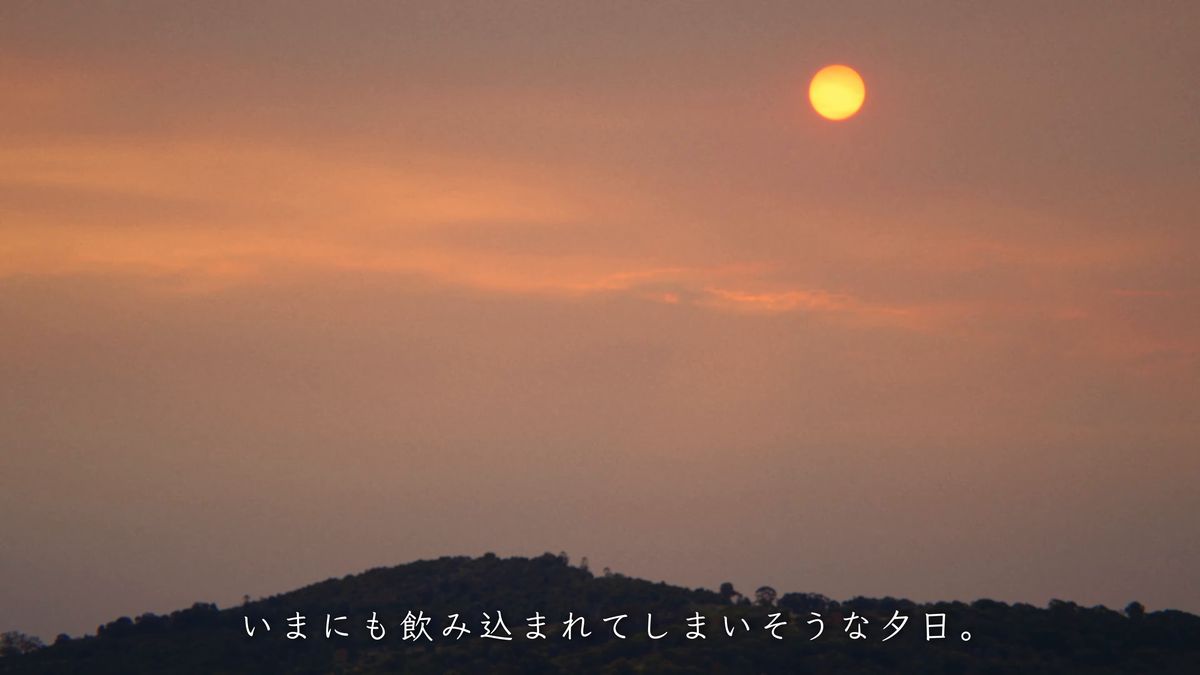 山の稜線に沈む赤い夕日