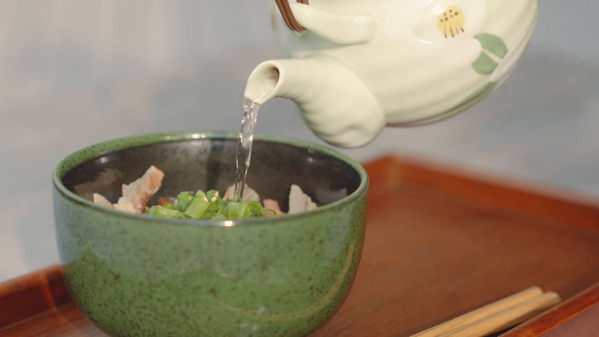 緑の茶碗に急須から出汁を注ぐ