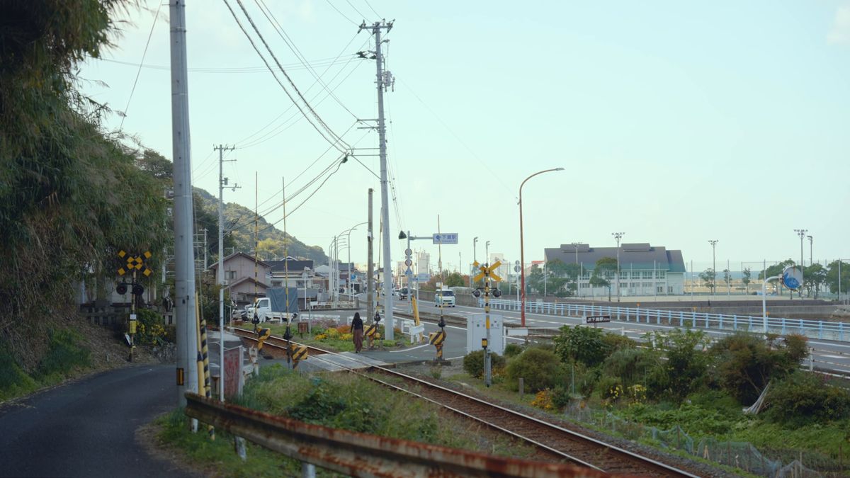 線路に沿って海へ下る道と踏切
