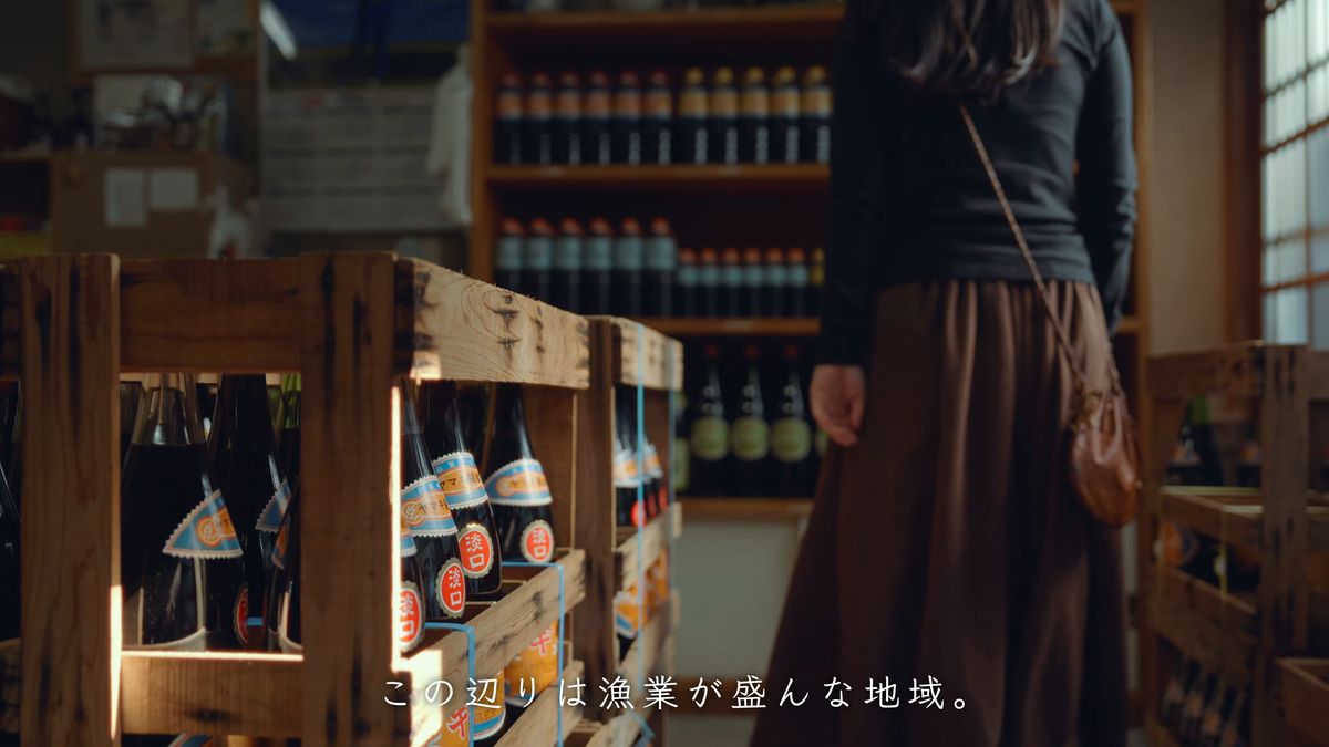 醤油の瓶が並ぶ店内に立つ後ろ姿