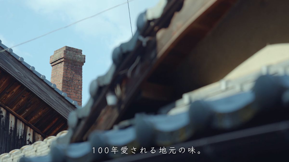 瓦屋根の向こうに立つ煉瓦の煙突