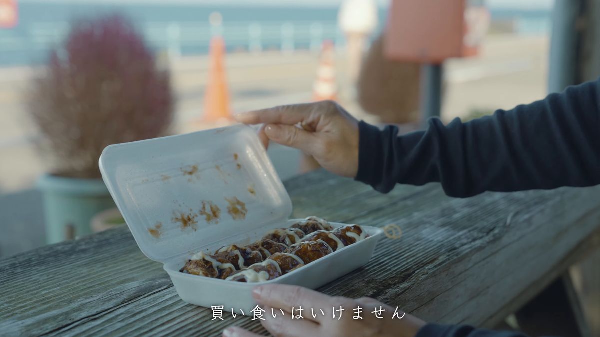 たこ焼きのパックを受け取る手元