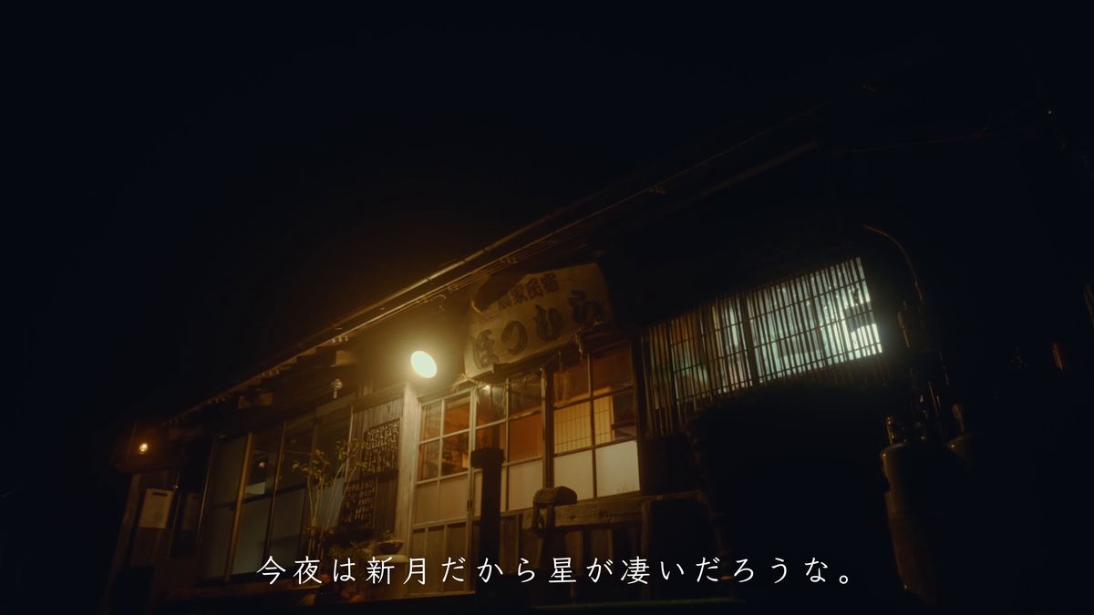 夜の闇に灯りがともる古民家の玄関