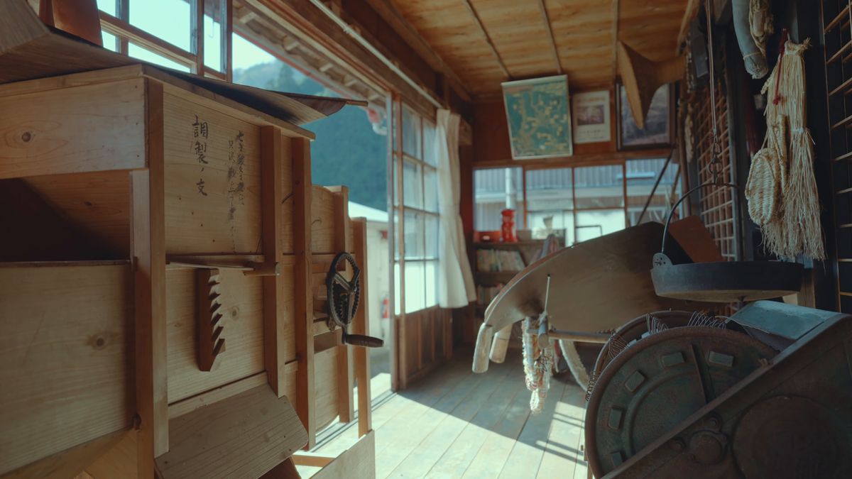 縁側に並ぶ古い木の箱と農具