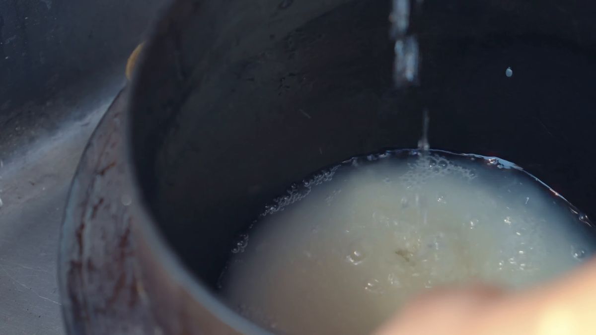 白く濁った研ぎ汁の中の米