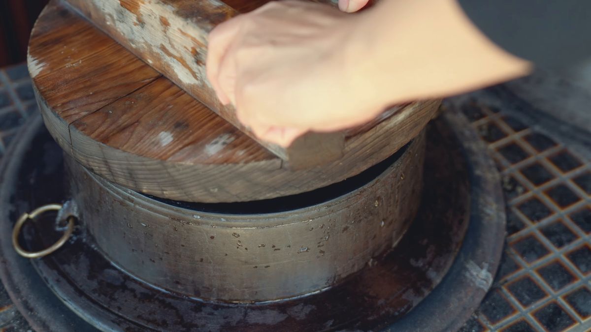 羽釜に木の蓋をのせる手元