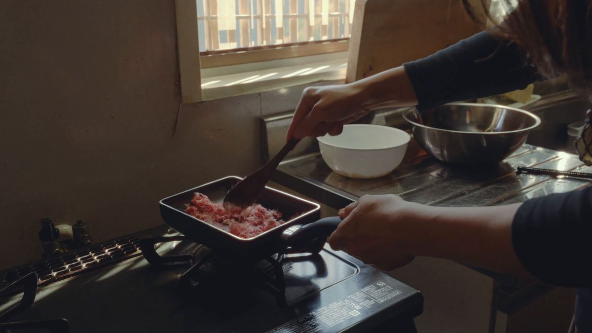 コンロの上でフライパンのでんぶを炒る手元
