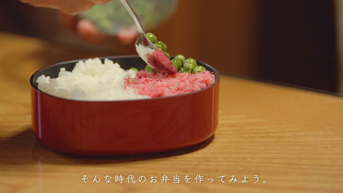 スプーンでえんどう豆を盛る手元