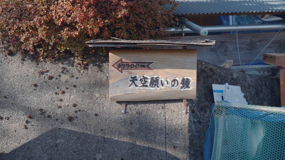 「天空願いの鐘」と書かれた木の案内板